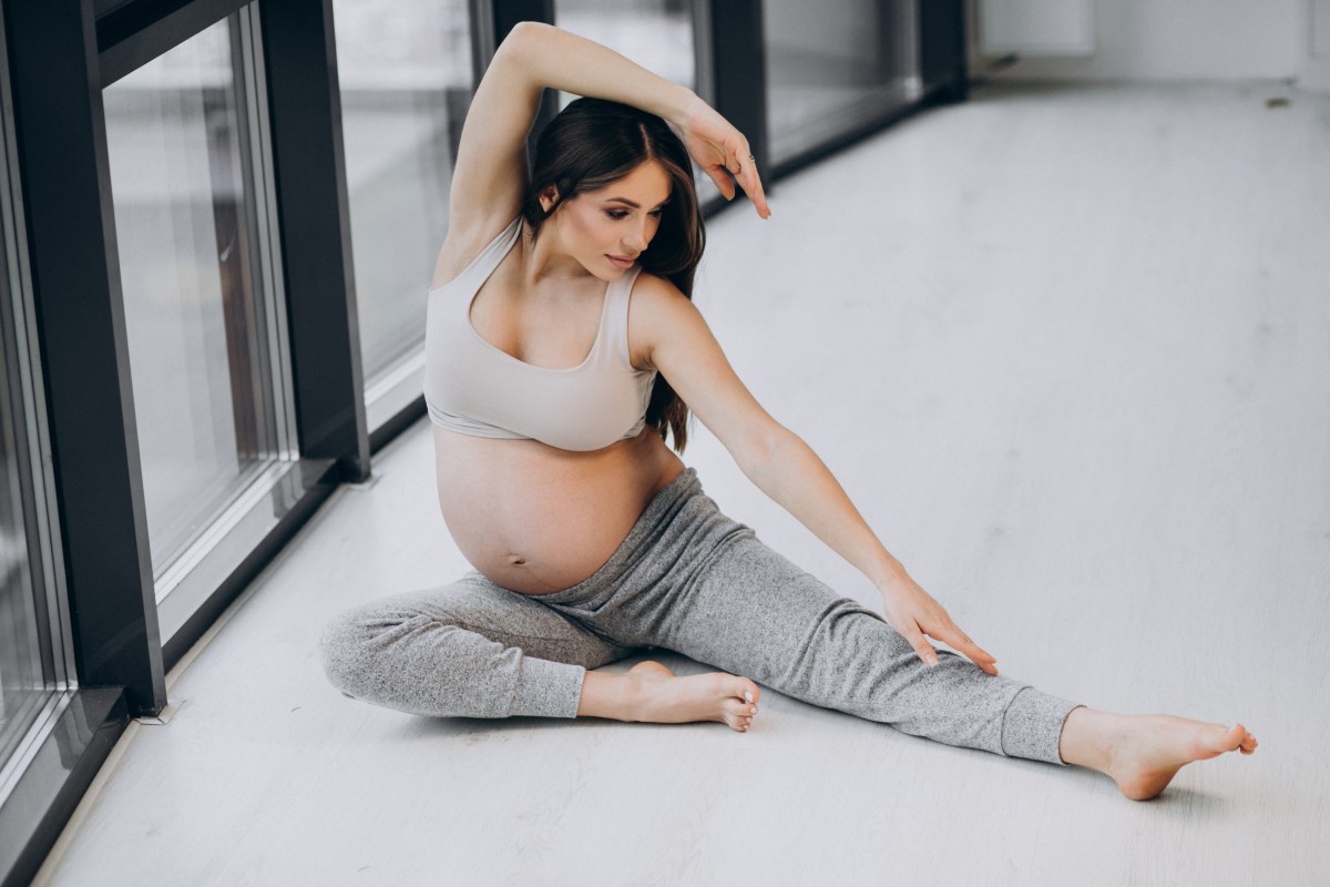 Pregnant Woman Practising Yoga Home By Window (1)